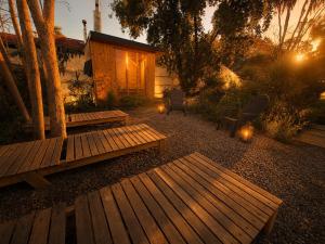 a backyard with two benches and a cabin with lights at Yucca Lodge en Colbún in Colbún
