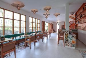 a dining room with tables and chairs and windows at Yulaman Hotel in Gili Trawangan