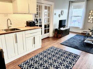 a kitchen with white cabinets and a sink and a television at Stylish Heritage Gem facing Stewart Park and Town Hall in Perth +24 photos