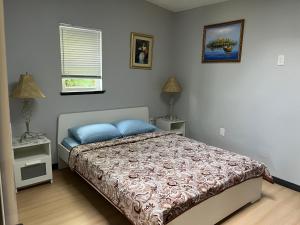 a bedroom with a bed and two lamps and a window at Lantzbnb front view in Lantzville