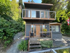 a tiny house with a staircase leading to the front door at Lantzbnb front view in Lantzville