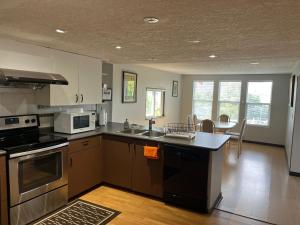 a kitchen with a sink and a stove top oven at Lantzbnb front view in Lantzville