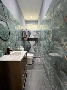 a bathroom with a sink and a toilet at "Selva maya stay" kitchen and spacious private parking in Flores +31 photos