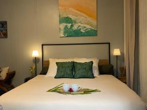 a bedroom with a bed with two cups on it at L'Isménia, L'écrin Zen in Le Gosier