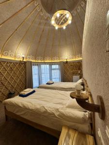 a bedroom with two beds in a room with a ceiling at Tangnuru eco yurts in Bosteri
