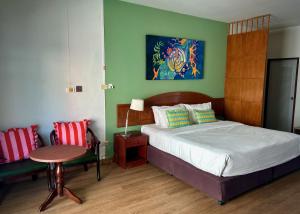 a bedroom with a bed and a table and a chair at Sugar and Spice Inn in Kata Beach +123 photos