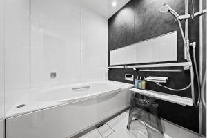 ein weißes Badezimmer mit Badewanne und Waschbecken in der Unterkunft Violet Garden in Furano + 54 Fotos