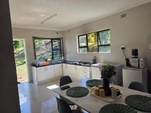 a kitchen with a table with chairs and a tableasteryasteryasteryasteryasteryastery at Mutare Fairbridge Executive Suites in Umtali