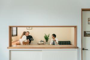 Ein Spiegel, der zwei Personen in einem Wohnzimmer reflektiert in der Unterkunft Hagi micro hotel in Gero