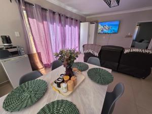 a living room with a table with chairs and a couch at Mutare Fairbridge Executive Suites in Umtali