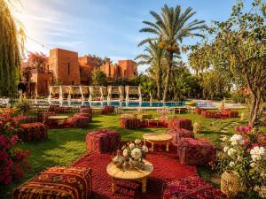 a garden with chairs and tables and a pool at Jnan Lotf Marrakech - Le Jardin de la Bienveillance in Marrakesh
