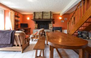 a living room with a wooden table and a fireplace at Maison Mitoyenne Avec Spa in La Chapelle-Urée