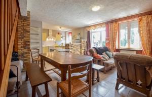 a kitchen and living room with a table and chairs at Maison Mitoyenne Avec Spa in La Chapelle-Urée