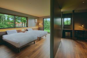 two beds in a room with two windows at Villa El Cielo Myoko in Myoko