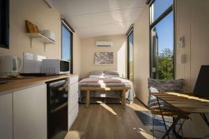 a small room with a bed and a table in it at Tiny Tallowood by Tiny Away in Glenreagh +29 photos