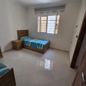 a small bedroom with a bed and a window at Lmadghri6 in Ras El Ma