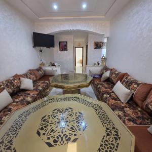 a living room with a couch and a glass table at Lmadghri6 in Ras El Ma