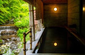 a walkway in a building next to a river at Oyado Hisaya in Muraoka +166 photos