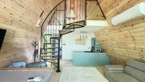 a spiral staircase in a living room with wooden walls at Fészek Lombház in Kismaros