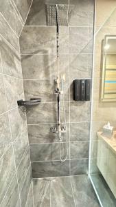 a bathroom with a shower with a glass door at Fészek Lombház in Kismaros