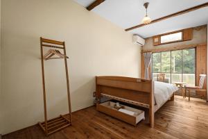 a bedroom with a bed and a room with a window at The Deer Park Inn in Nara