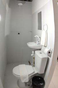a white bathroom with a toilet and a sink at Quarto 8km Aeroporto MCZ in Maceió