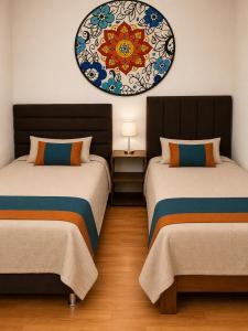 a room with two beds and a painting on the wall at Terra House Hostel in Cusco