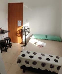 a bedroom with a bed and a fan in it at Quarto 8km Aeroporto MCZ in Maceió