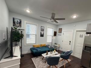 a living room with a blue couch and a table at Modern & Spacious Apartment 15 Min to NYC Near MetLife & American Dream in Jersey City