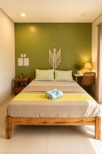 a bed in a room with a green wall at Hooga Home in Cebu City