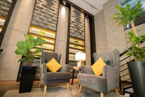 a lobby with two chairs and a table with yellow pillows at Changi Transit Hotel Terminal 1 in Singapore