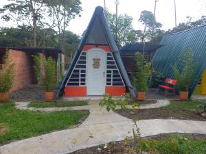 a small house with a door in a yard at Casa del Bosque in Mocoa