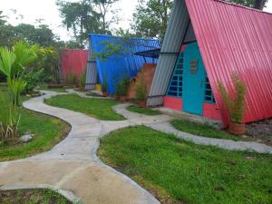 a path leading to a house with colorful doors at Casa del Bosque in Mocoa