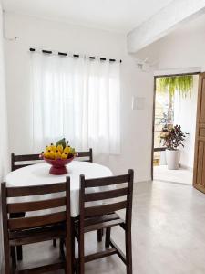 a dining room table with two chairs and a bowl of fruit at Casas do Matteo - 2ª Praia in Morro de São Paulo +54 photos