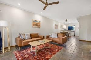 a living room with two couches and a table at Dunes Escape in Broome