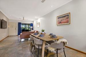 a dining room and living room with a table and chairs at Dunes Escape in Broome