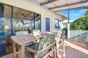 a wooden table and chairs on a patio at Dunes Escape in Broome