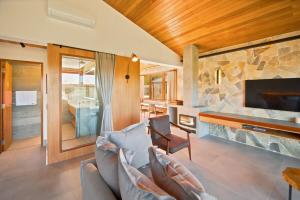 a living room with a couch and a stone fireplace at Casa ALPIN in São José dos Campos