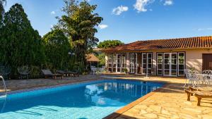 a swimming pool in front of a house at Pousada da Sirlei in Tiradentes