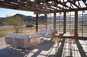 a porch with chairs and a table and a view at The Giddyup in Pioneertown