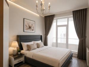a bedroom with a large bed and a window at Sakura Apartments in Astara