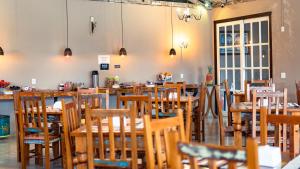a dining room with wooden tables and chairs at Pousada da Sirlei in Tiradentes