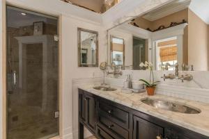 a bathroom with two sinks and a shower at Villa Grand Horizon in East Hampton +31 photos