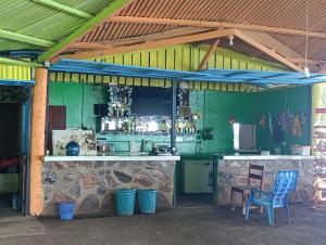 a kitchen with a counter in a green building at Kencho's Beach House-Sunset & Beachside stay in Ometepe in El Perú