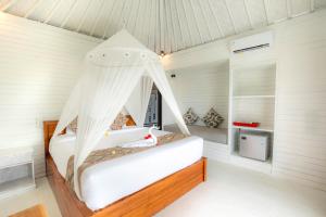 a bedroom with a bed with a mosquito net at Blue Lagoon Secret Villas in Nusa Lembongan
