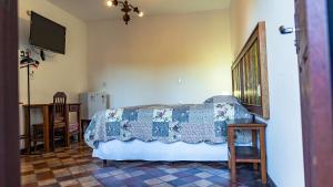 a bedroom with a bed and a table and a television at Pousada da Sirlei in Tiradentes
