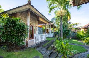 a house with a porch and a palm tree at Blue Lagoon Secret Villas in Nusa Lembongan +19 photos