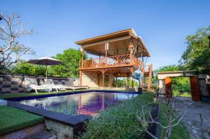 a house with a swimming pool and a house with a deck at Blue Lagoon Secret Villas in Nusa Lembongan