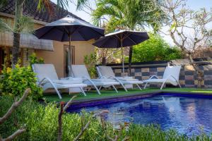 a group of chairs and umbrellas next to a pool at Blue Lagoon Secret Villas in Nusa Lembongan