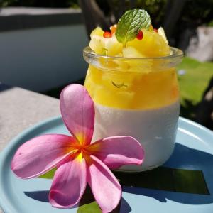 a drink on a plate next to a flower at Lokal Hotels Dauin in Dauin